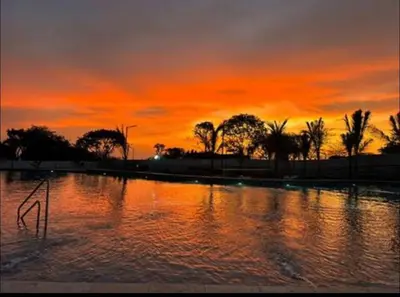 a sunset over a pool of water with palm trees at Apto 1417 condominio Santa marina, Santa Marta in Estación El Salto