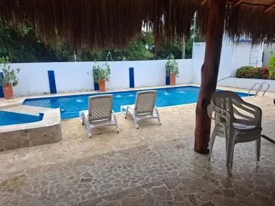 a group of chairs sitting next to a swimming pool at Finca Villa Gabriela