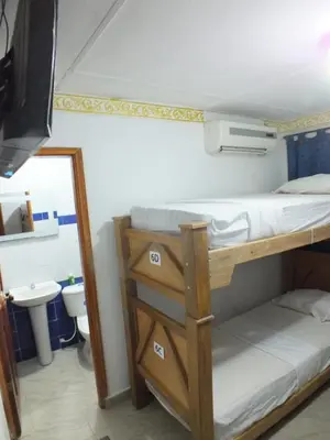 a bunk bed in a room with a sink and a mirror at Hotel Nuevo Horizonte in Barranquilla