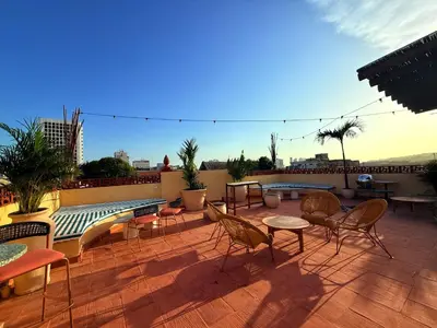 a patio with chairs and tables on a roof at Masaya Cartagena in Cartagena de Indias