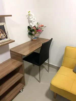 a desk with a vase of flowers and a chair at Lofts Mediterraneo in Barranquilla