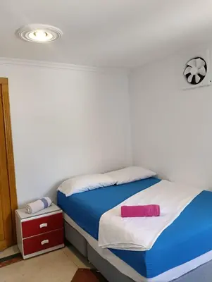 a bedroom with a bed with blue and white sheets at Acogedor Apartaestudio Laguito 1 Habitacion N4A2 in Cartagena de Indias
