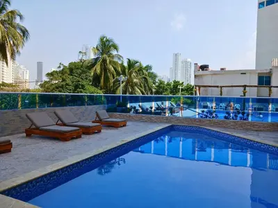 a swimming pool with lounge chairs and a building at Atardeceres del Laguito in Cartagena de Indias
