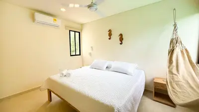 a bedroom with a bed and a hammock at Cabaña Tierramia 3 in San Silvestre