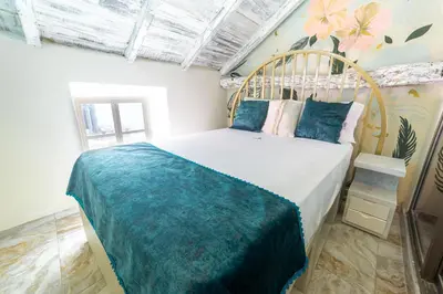 a bedroom with a bed with a wooden headboard at Sublime Hotel Cartagena in Cartagena de Indias