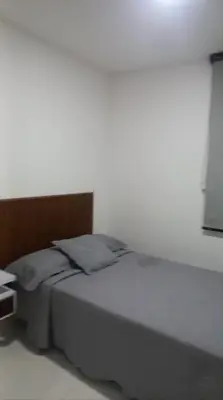 a bed in a bedroom with a white wall at Hermoso apartamento in Cartagena de Indias