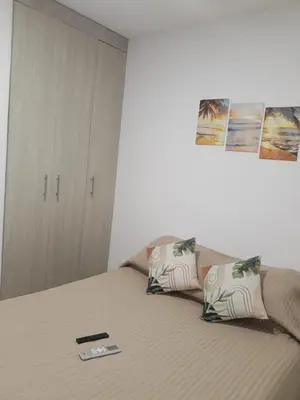a bedroom with a bed with a remote control on it at Great and affordable in Cartagena de Indias