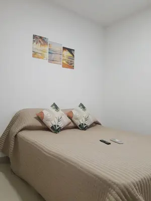 a bed in a room with two pictures on the wall at Great and affordable in Cartagena de Indias
