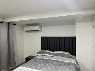 a bedroom with a bed with a black headboard at Aparta estudio confortable y completo in Barranquilla