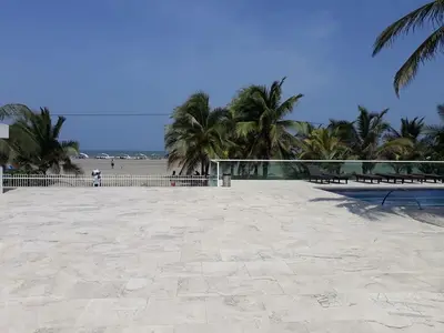 a large volleyball court on a beach with palm trees at Stunning 2BD Apartment Pool - Oceanview Cartagena in Cartagena de Indias