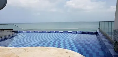 a swimming pool with the ocean in the background at Palmetto Eliptic Bahia in Cartagena de Indias