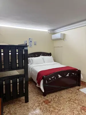a bedroom with a large bed with a red blanket at Hotel San Francisco Inn in Barranquilla