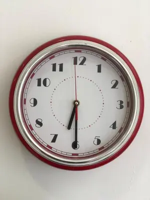 a clock is hanging on a white wall at Getsemani ballestrinqe in Cartagena de Indias
