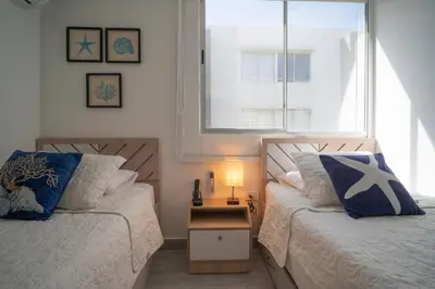 a bedroom with two beds next to a window at Refugio costero, Serena del Mar - Cartagena Indias in Serena del Mar