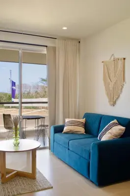 a blue couch in a living room with a table at Lujo y comodidad en Baia Kristal, Cartagena in Cartagena de Indias
