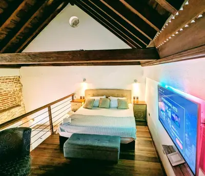 a bedroom with a bed and a flat screen tv at Duplex Colonial Getsemani in Cartagena de Indias