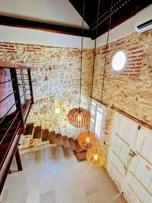 a room with stone walls and two hanging lights at Duplex Colonial Getsemani in Cartagena de Indias