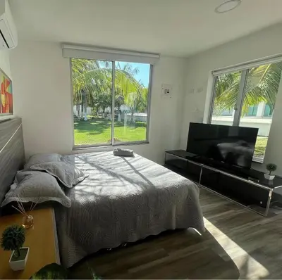 a bedroom with a bed and a large window at Casa Romero Cartagena Casa de Playa in Cartagena de Indias