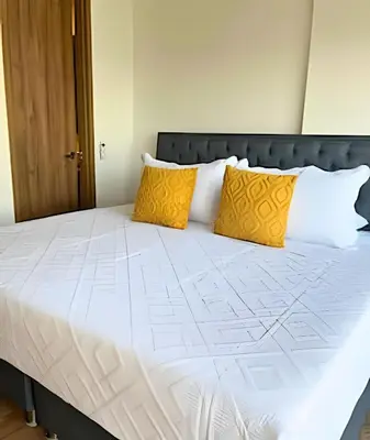 a bed with two yellow pillows on top of it at Spectacular apartment, unparallel views! in Cartagena de Indias