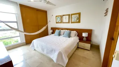 a white bedroom with a bed with blue pillows at Magico Apartamento Frente al Mar 3 Habitaciones TR72 in Coveñas