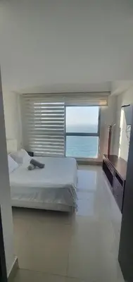 a bedroom with a bed and a view of the ocean at Lodging Apto 37 Palmetto Eliptic in Cartagena de Indias