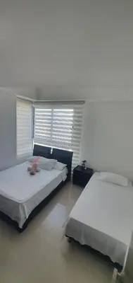 a bedroom with two beds and a window at Lodging Apto 37 Palmetto Eliptic in Cartagena de Indias