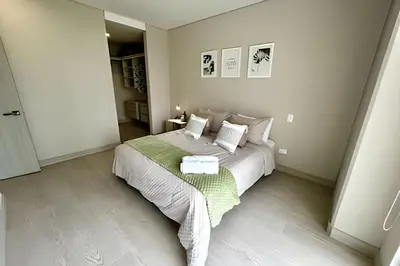 a bedroom with a white bed with a green blanket at Fantástico apartamento 505 in Cartagena de Indias