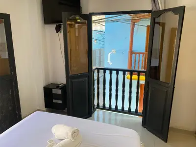 a room with a bed and a balcony at Hotel Casa Lopez - Cartagena in Cartagena de Indias