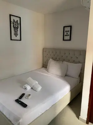 a white bed with two remote controls on it at Hotel Casa Lopez - Cartagena in Cartagena de Indias