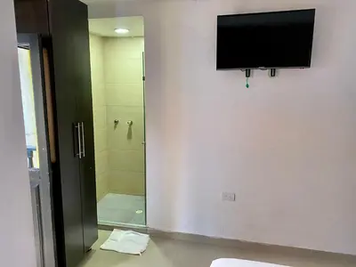 a bathroom with a shower and a television on the wall at Hotel Casa Lopez - Cartagena in Cartagena de Indias