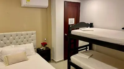 a small room with two bunk beds and a bed sidx sidx sidx at Hotel Casa Lopez - Cartagena in Cartagena de Indias