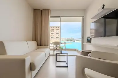 a living room with a couch and a large window at Espectacular vista a laguna de Kristal / 1 alcoba in Los Arrayanes