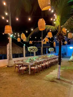 a long table with tables and chairs and lights at Cabaña 5 - Conjunto frente al mar con piscina in Coveñas