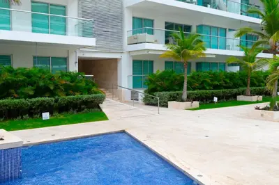 a villa with a swimming pool in front of a building at The Beaches-Beachfront Retreat in Cartagena de Indias
