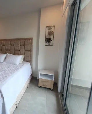 a bedroom with a bed and a glass door at Apartamento Santa Marta Sector Don Jaca in Simón Bolivar