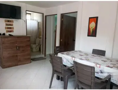 a dining room with a table and chairs and a television at Cabaña el cielo in Lorica