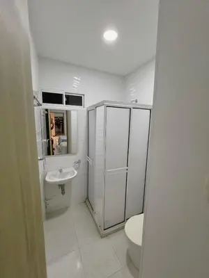a white bathroom with a toilet and a sink at New house in Barranquilla in Barranquilla