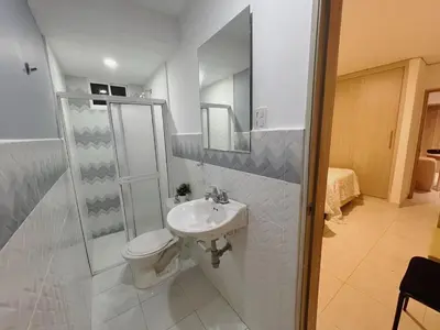 a white bathroom with a toilet and a sink at New house in Barranquilla in Barranquilla