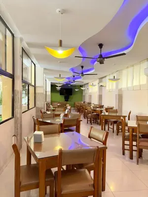 a restaurant with tables and chairs and purple lighting at Hotel San Francisco in Barranquilla