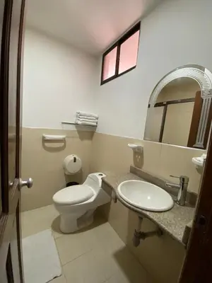 a bathroom with a toilet and a sink and a mirror at Hotel San Francisco in Barranquilla