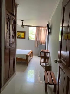 a bedroom with a bed and a table and a door at Hotel San Francisco in Barranquilla