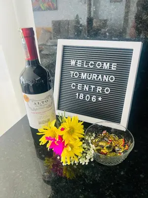a bottle of wine next to a bowl of flowers at Modern Sunset Stay Cartagena in Cartagena de Indias