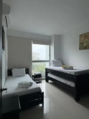 a bedroom with two beds and a large window at Apartamento en Cartagena a pasos de la Playa in Cartagena de Indias