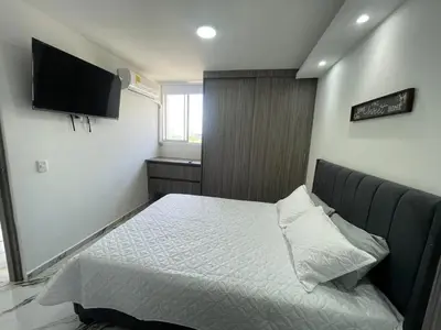 a bedroom with a bed and a tv on the wall at Apto Hermoso Samu in Barranquilla