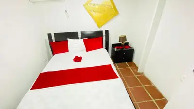 a bedroom with a red and white bed in a room at Apartamentos las palmas in Cartagena de Indias
