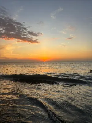 a sunset on the beach with the ocean at VILLA LILI Santa Marina Santa Marta in Santa Marta