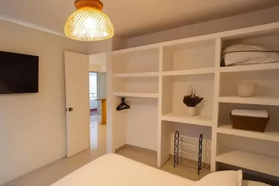 a room with white shelves and a light fixture at Hermoso apartamento cerca del Hotel Las Americas y Playa Azul in Cartagena de Indias