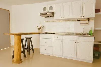 a kitchen with white cabinets and a wooden table at Hermoso apartamento cerca del Hotel Las Americas y Playa Azul in Cartagena de Indias
