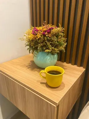 a vase of flowers and two cups on a table at apartamento miniluxxury in Barranquilla