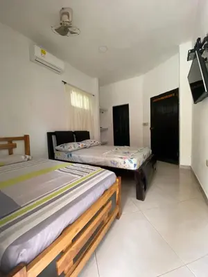 a bedroom with two beds and a tv in it at Habitacion Pauvemar en Coveñas in Coveñas